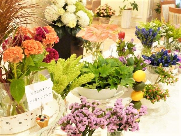 白い器に色とりどりの花が飾られている