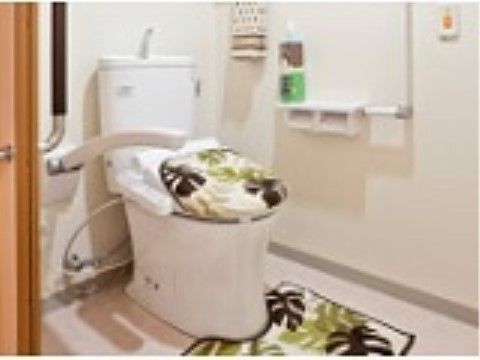 揃いの便座カバーとマットがおしゃれな雰囲気を作り出しているトイレの個室