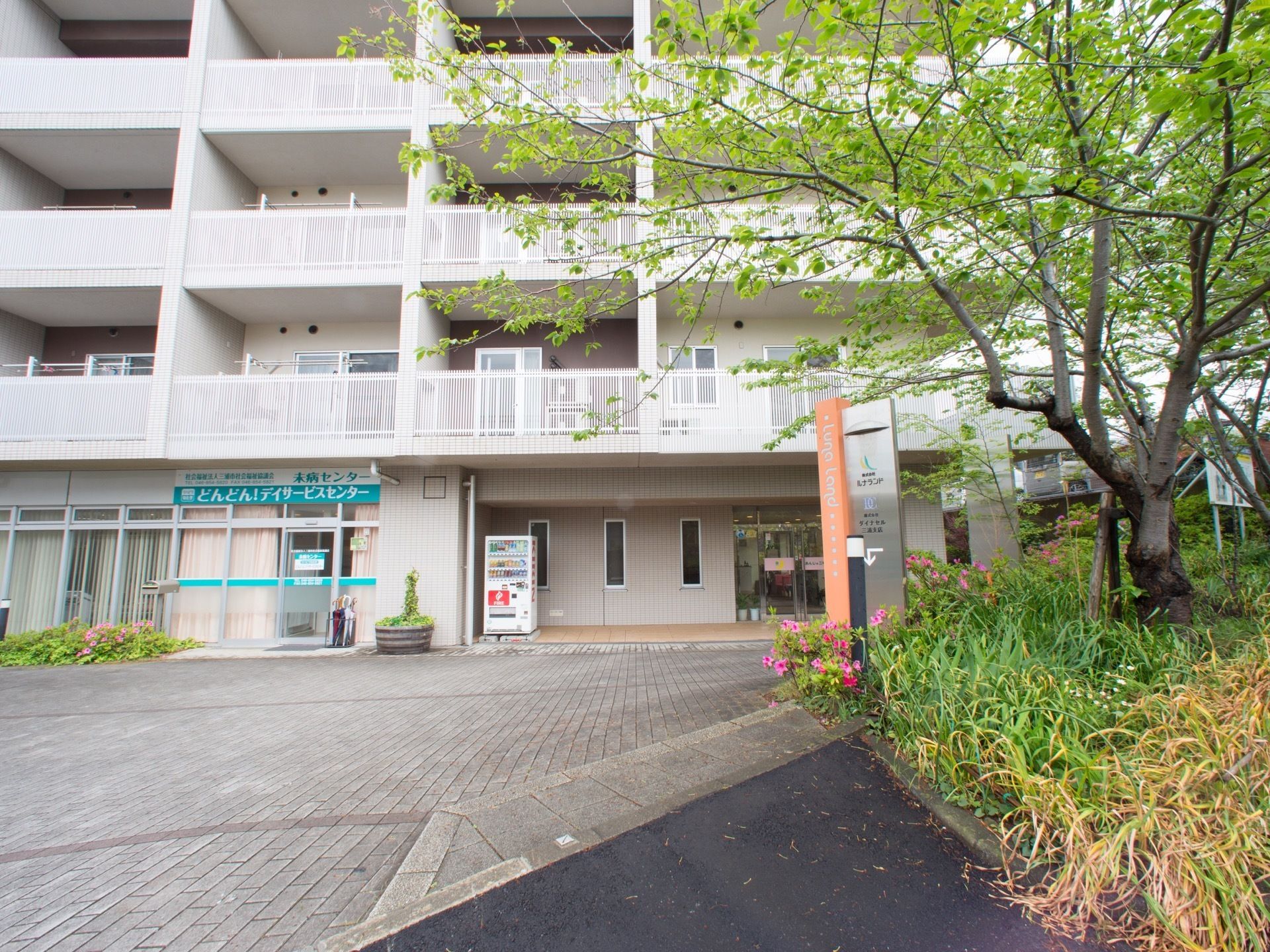 施設は集合住宅となっており、デイサービス施設の入口が並んでいる。入口の横に自動販売機が設置されており、こまめに水分補給をすることができる。