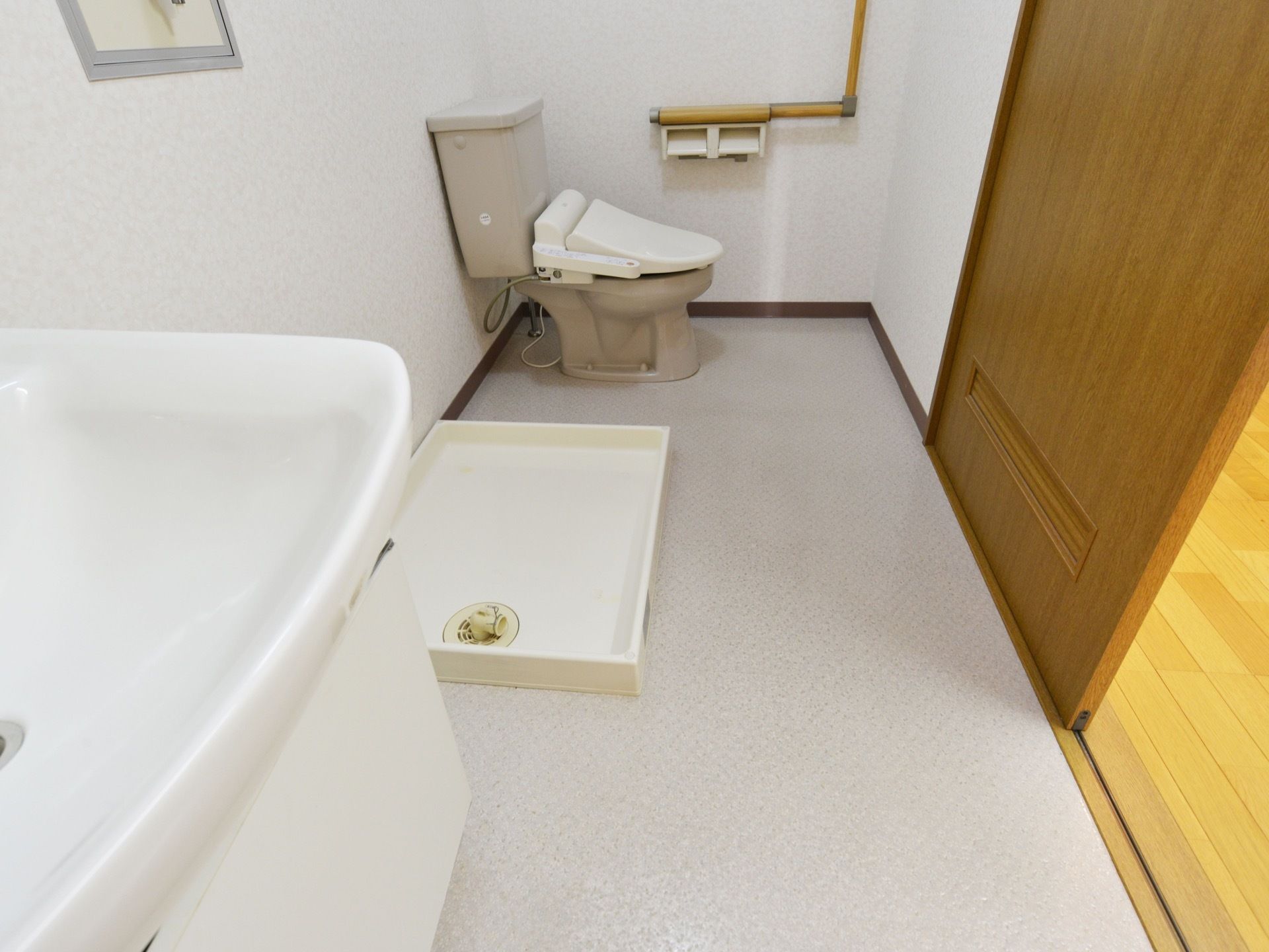 居室内には温水便座付きのトイレ、洗濯機置き場、洗面台が１つのスペースに設置されている。片引き戸で開閉しやすい。
