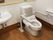 トイレと洗面台がある。トイレの壁側にはトイレットペーパーフォルダー2つある。また、便器の両側には手すりが取り付けられている。