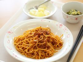 白のトレイにメインのミートソースを含めて3品が用意されている。デザートにはフォークも用意されている。