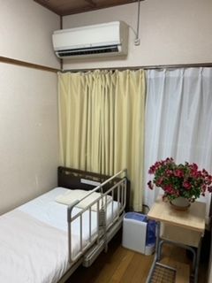 茶色と白で統一され、エアコンや扇風機が設置された居室