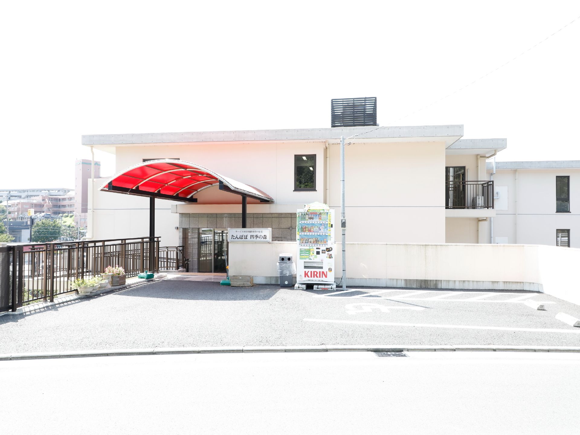 施設の入口前には車椅子専用の駐車スペースが設けてある。入口までのアプローチには赤いアーチ型の屋根が付いている。
