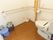 便器の周りには広い空間がある。壁を囲むように手すりがあり、正面の壁にはトイレの掃除用具やゴミ箱などがある。