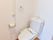 居室のトイレはドアのある個室タイプではなく、カーテンが仕切りになっている。右手側には手すりとタオル掛けがある。