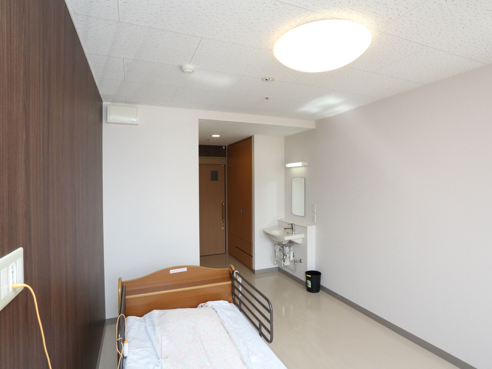 介護用ベッドが設置された居室には、洗面台や収納クローゼットが完備されている。フラットな床面で移動しやすい。
