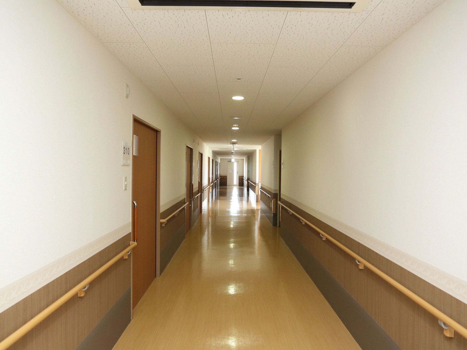 ブラウン系統でまとめられた居室前の廊下である。両サイドには、手すりを設置しているので安全な歩行ができる。