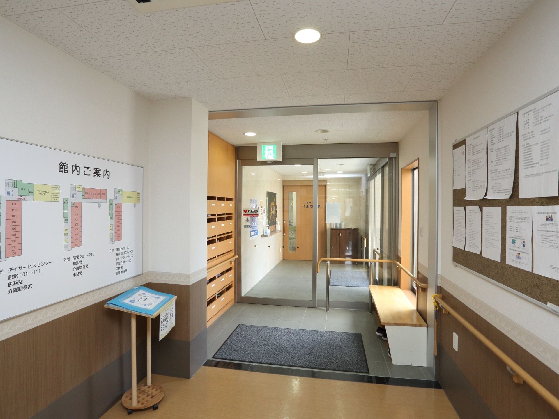 玄関には、館内案内図のプレートが展示されている。完備されている靴箱の側には、泥落としマットやベンチが置かれている。