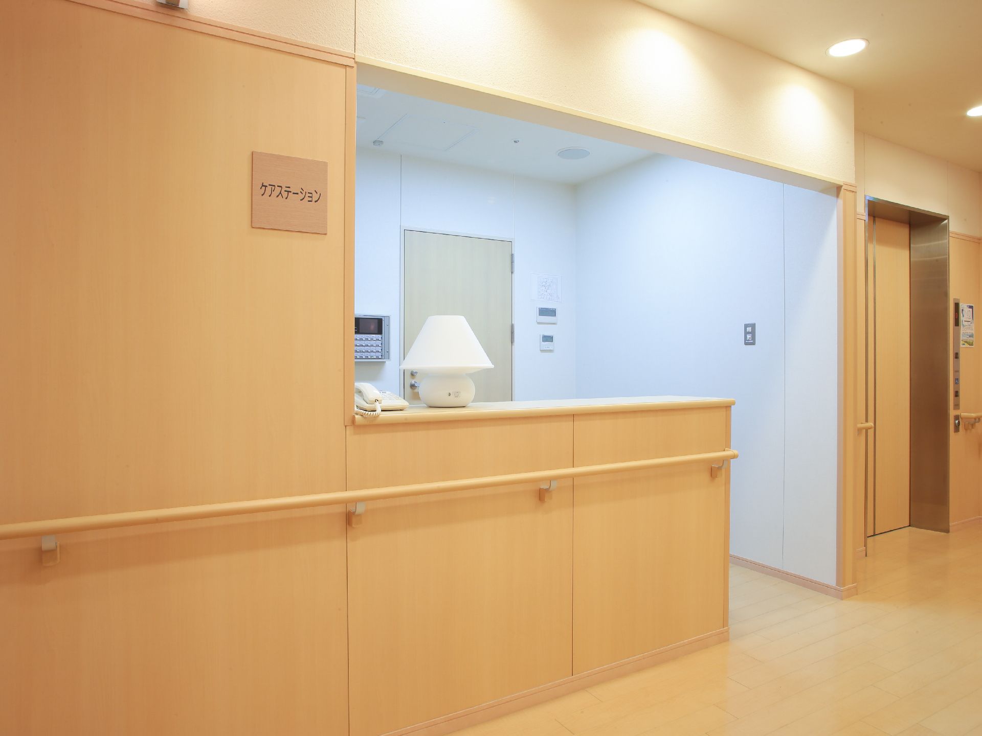 内部は白色で外部は木目仕様の設計になっている。壁には手すりが設置され、カウンター台の上には電話機と照明スタンドが置かれている。