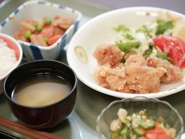 健康に配慮されて施設では食事が作られている。唐揚げを主菜に副菜が数品とご飯に味噌汁などが用意されている。