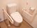 右側の壁にはナースコールや手すり、トイレットペーパーが敷設されており便器を挟んで向かい側にも手すりが設置されている。