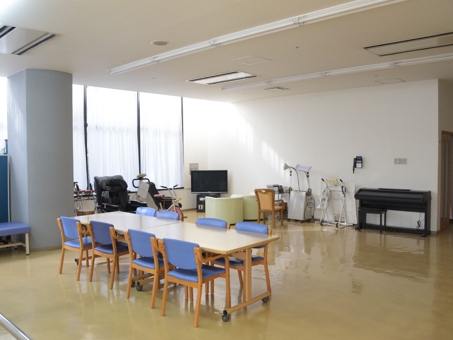 大きな窓からは陽光が差し込んでいる。木目調のテーブルが部屋の中央に置かれており8脚の椅子が向かい合わせに並べられている。