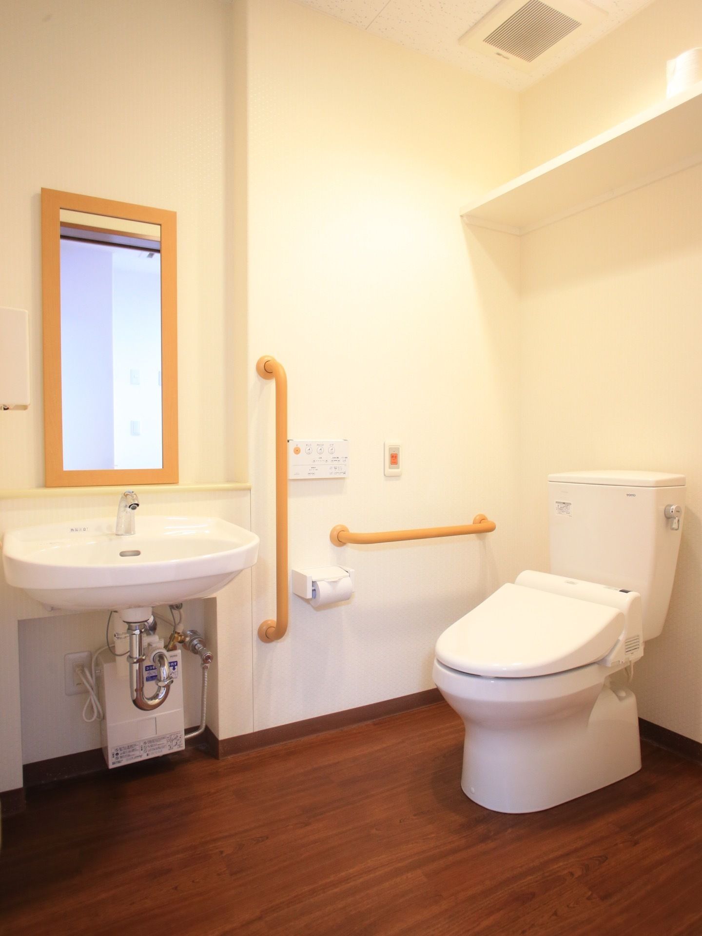 トイレは、フローリングの床と白い壁で統一された内装となっている。室内には、トイレと洗面台が設置されている。