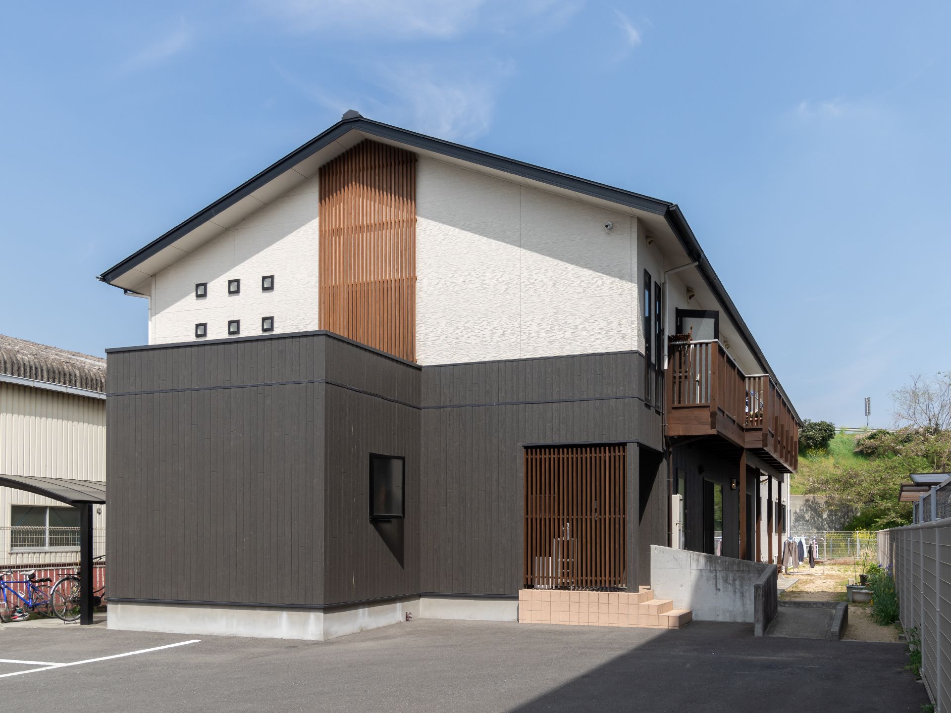 晴れ渡った青空に、色の濃い大きな屋根が印象的な建物。大きな屋根の下には、アットホームな空間が広がっている。