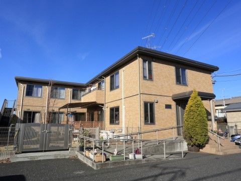 「グループホームいずみ別荘」外観。ベージュ色の穏やかなデザインが、施設の温かさを演出しています。