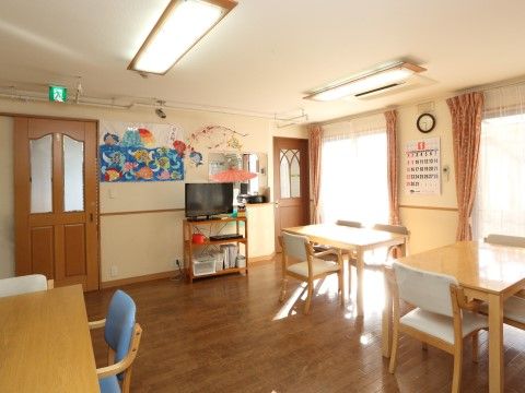 「グループホームいずみ別荘」食堂。共有テレビが置かれてあり、壁にはカレンダーが掛かっています。