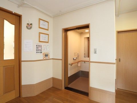 「グループホームいずみ別荘」エレベーター。出入口には観葉植物が置かれてあり、中には手すりが備え付けてあります。