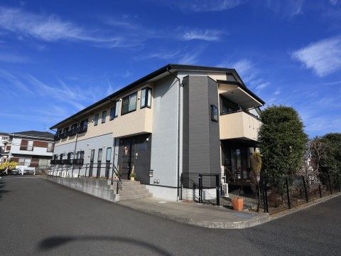 「グループホームいずみ別荘２」の外観。3階建ての灰色広い敷地。
