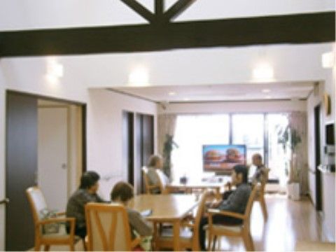 部屋の奥には、大きなテレビが一台設置され、大きなダイニングテーブルが中央に置かれた談話スペース