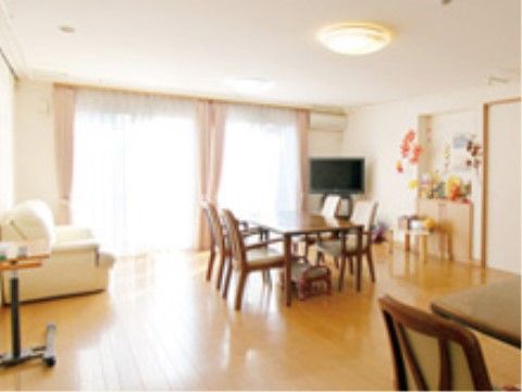 窓から陽の光が差し込み、間隔をあけてテーブルセットが配置された開放感のある多目的スペース