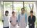 女性3人が男性1人のスタッフが並んでいる写真。中央の2人はエプロンを付けている。背後にサッシがあり、外の植木や塀が見える。