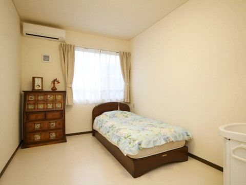 エアコンが設置され、ベッドの傍には衣装棚が置かれた寝室
