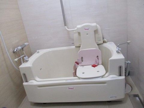 座ったままの姿勢で入浴可能な機能を持つ介護入浴機器が設置された浴室である。シャワー、混合栓が取り付けられている。