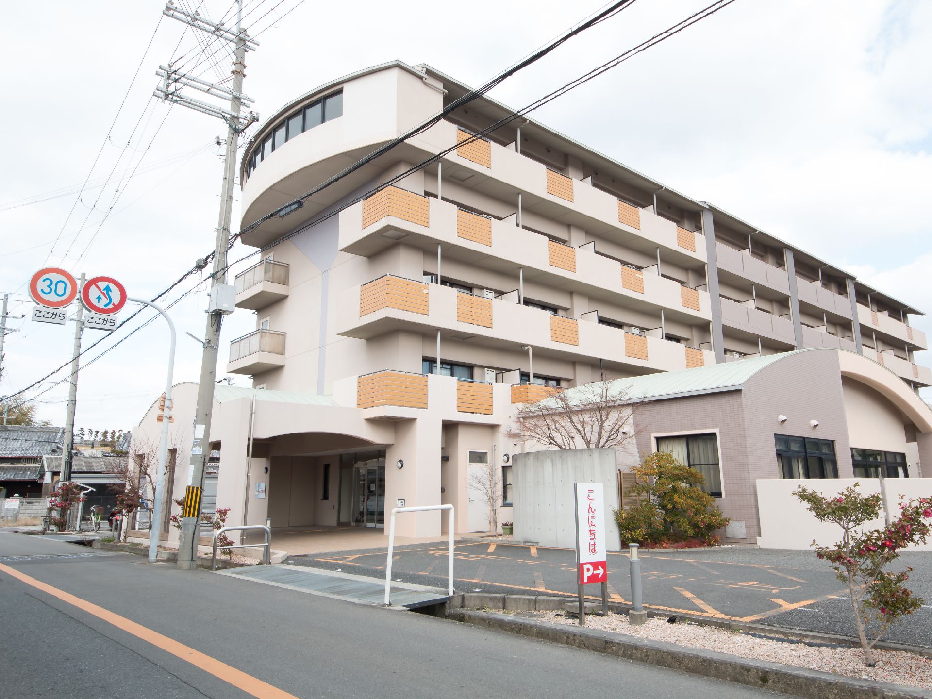 横から見ると5階建ての一般的な集合住宅のような外観。車寄せがあるので、雨の日も濡れずに建物に出入りすることができる。