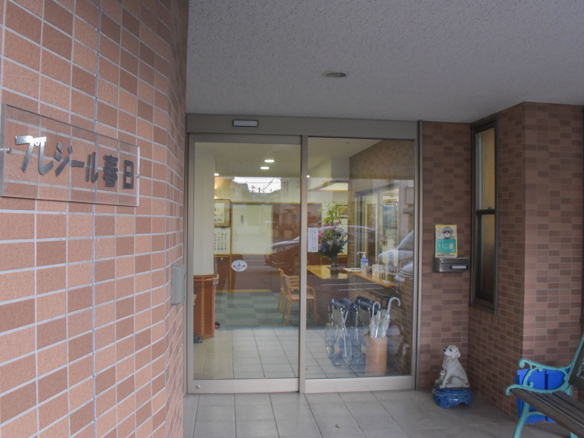 エントランスは段差のないバリアフリーとなっている。また入り口には自動ドアを設置していて、ベンチが置かれている。