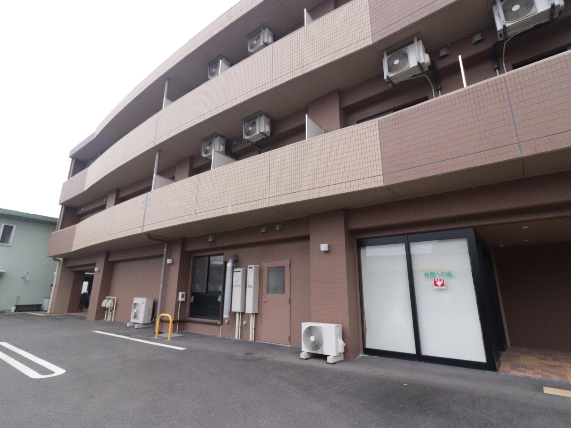 施設の建物は３階建てである。アパートのような造りになっている。各部屋にベランダがあり、上部に室外機が取り付けられている。