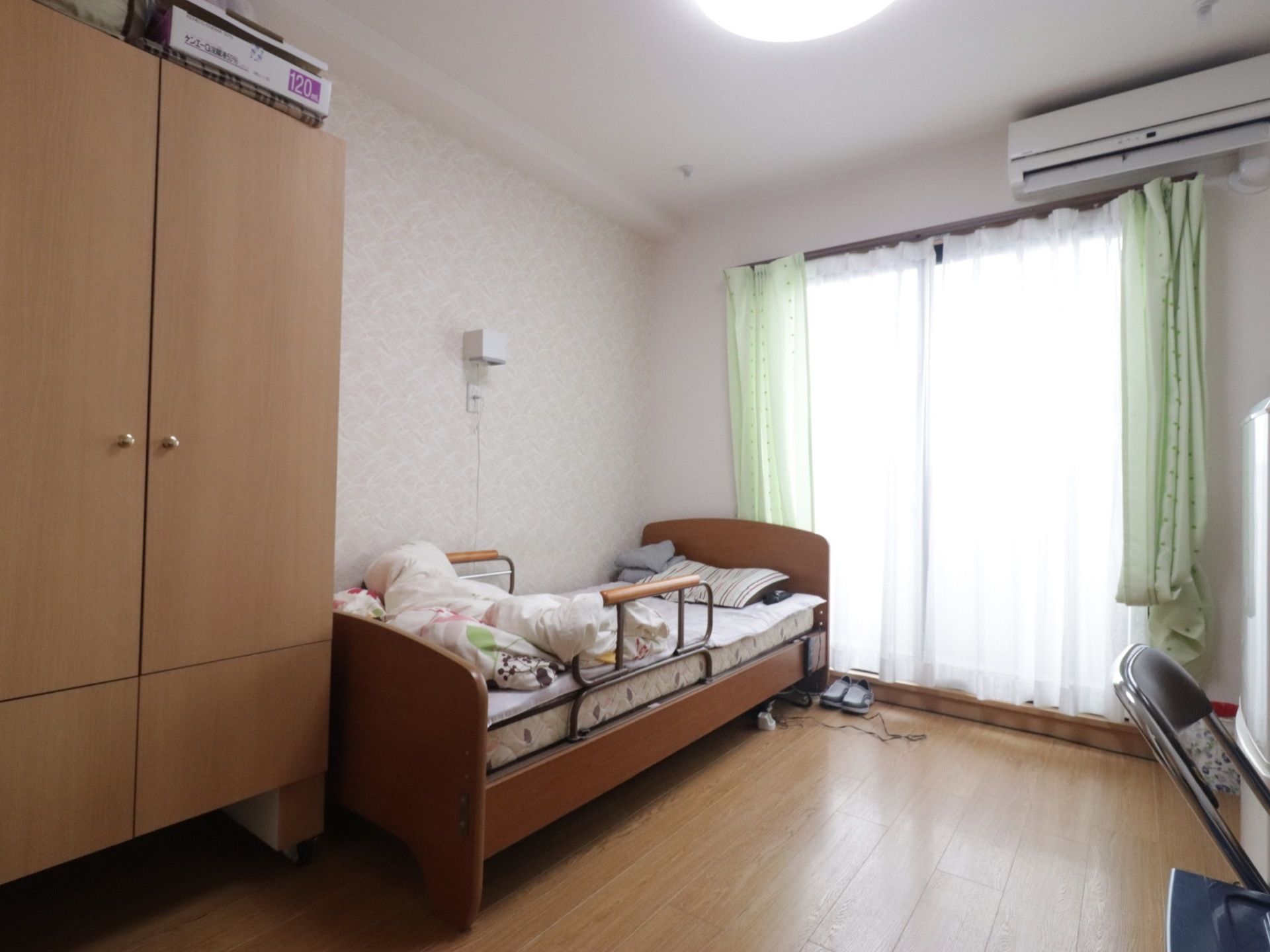 大きな窓がある一人部屋。空調も完備されている。ベッドには手すりが付いており、補助がなくても一人で寝起きできる。