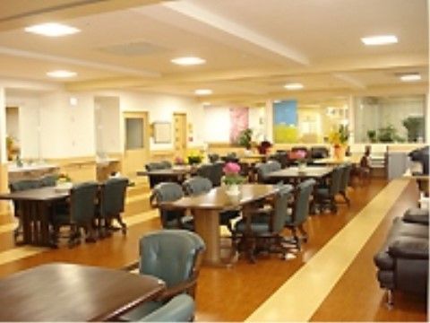 洗面台が備え付けられている食堂。４人掛けのダイニングテーブルとゆったりと座れる１人掛けの椅子が複数セッティングされている。