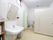 入居者様トイレには、カーテン扉と大きな白い扉のトイレが設置されている。室内にある手洗い場の正面には、大きな鏡も取りつけられている。
