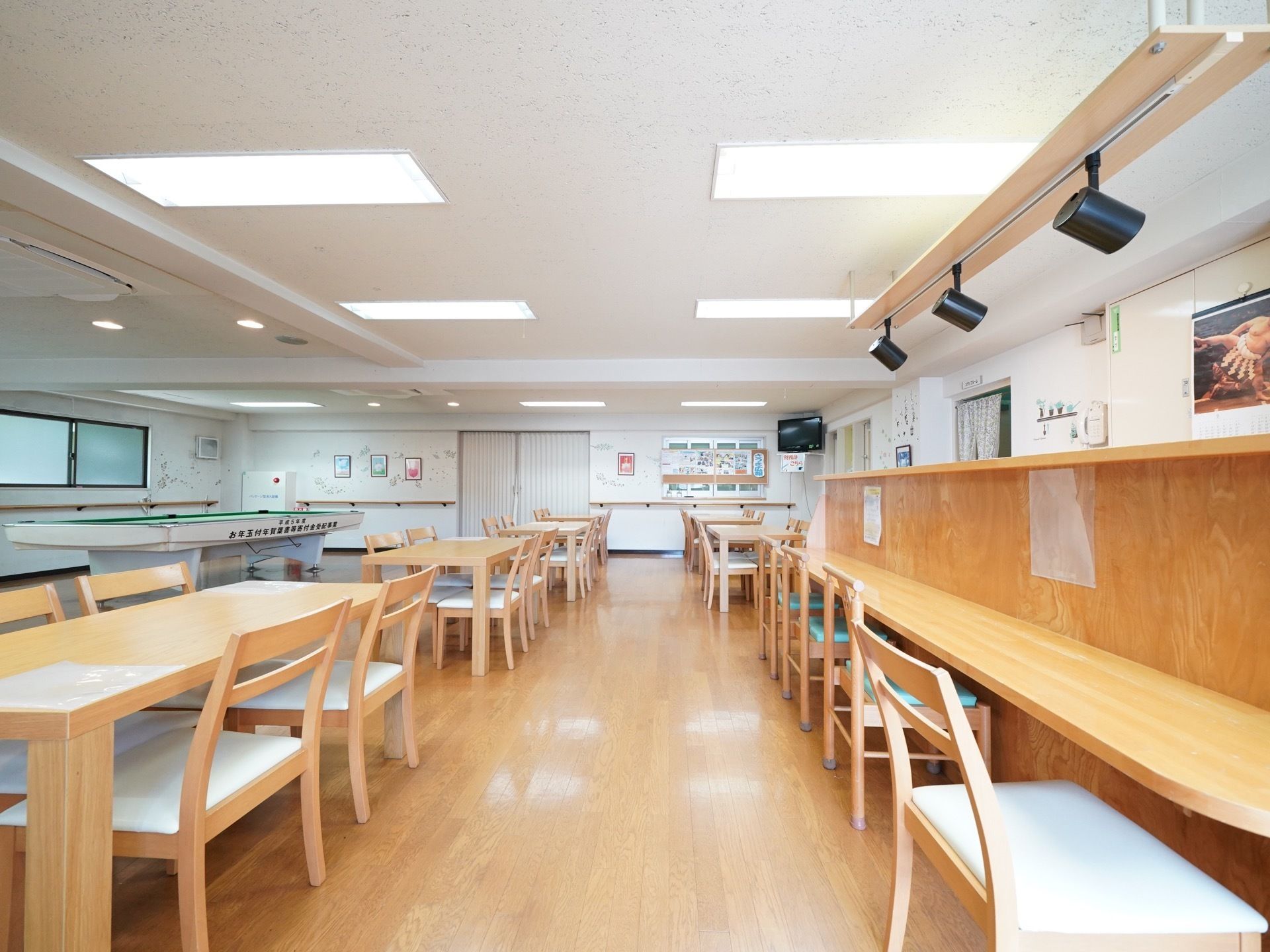 食堂には、テーブルや幅の広い椅子が多く置かれている。照明は天井に埋め込まれていて、すっきりとした印象である。ビリヤード台も置かれている。