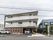 3階建ての施設は1階の右側が玄関や送迎車が駐車できるようになっている。2、3階部分はベランダが建物を囲むように設置されている。