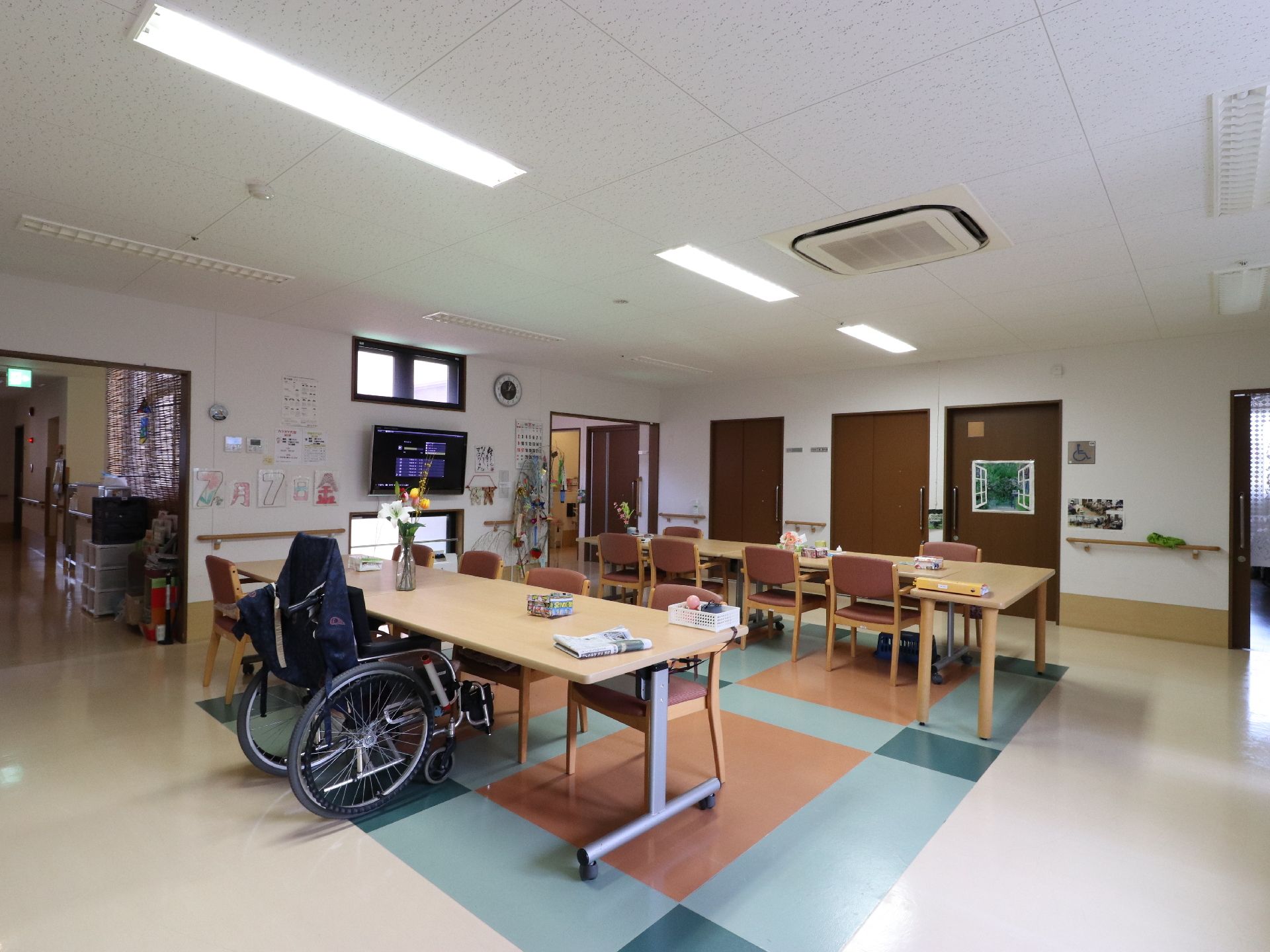 同じテーブルで車いす利用者の方も食事を摂れるよう、食堂には広くスペースをとっている。手すりやテレビが設けられている。
