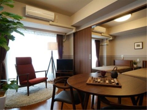 合間を扉で仕切ることができ、ブラウンを基調とした家具が設置された部屋