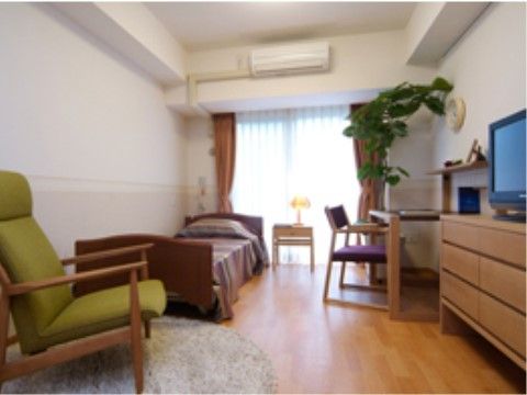 居室にはエアコンやベッド、タンスにスタイリッシュな机が備え付けてある。バリアフリー設計で安心して生活することができる。