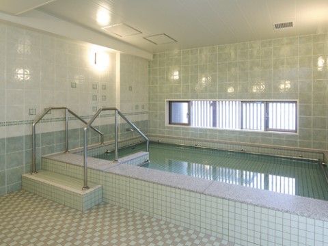 大浴場にはプールのような大きな浴槽があり、手足をしっかりと伸ばして入浴することができる。手すりや階段がついていて、安全に入ることができる。