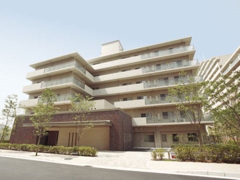 建物前にグリーンを配置した6階建ての施設外観