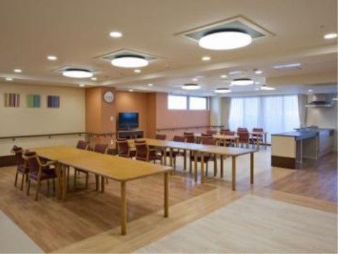 大きな長テーブルが平行に置かれ、周辺にいくつもの椅子が並ぶ広いダイニングルーム