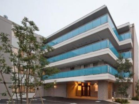 ブルーの目隠しフェンスが設置されたベランダのある、アイボリーの建物