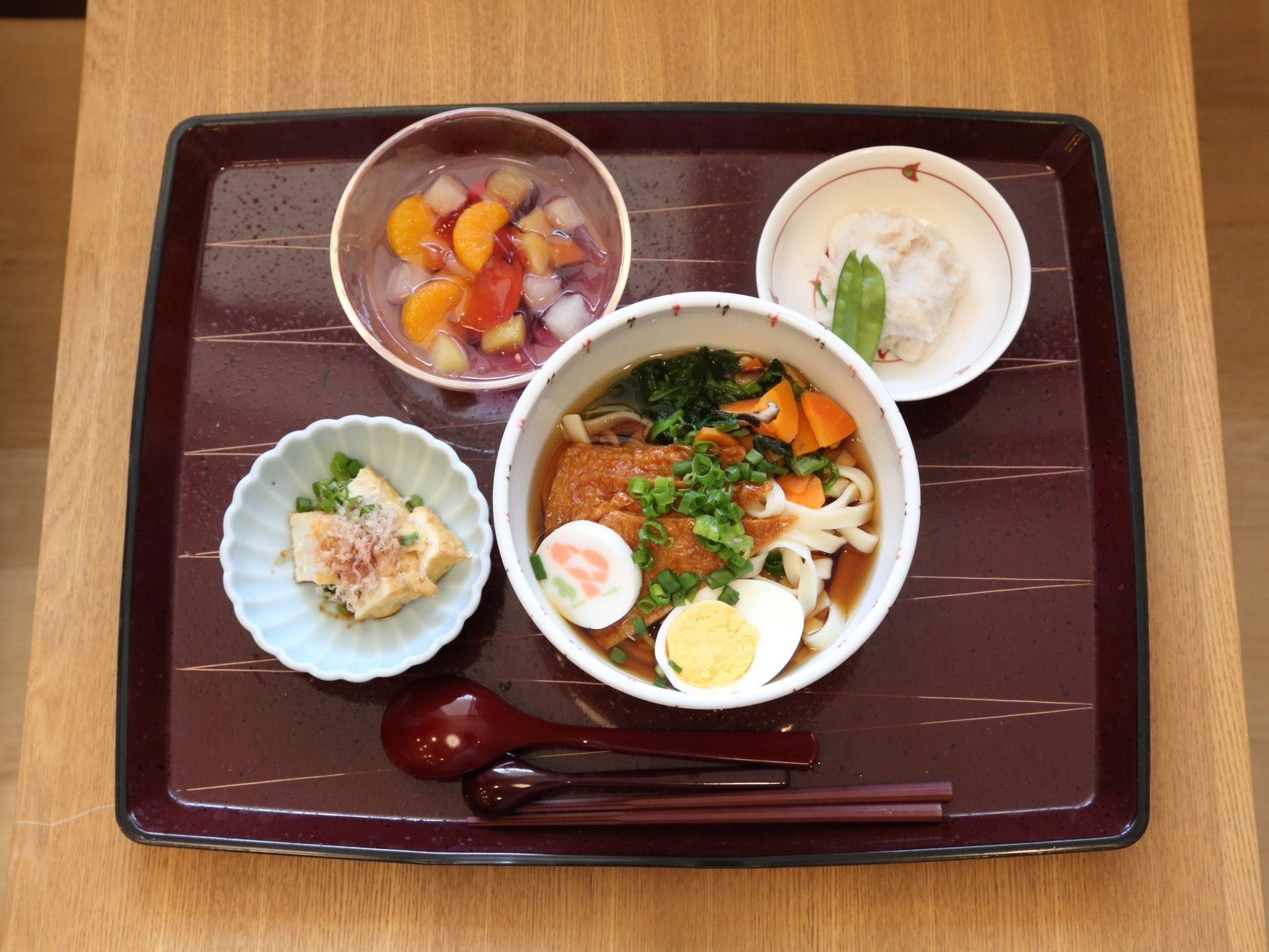 この日は、麺類がメインの食事である。小鉢のおかずが２品、デザートにはフルーツポンチが添えられている。栄養バランスと彩りにも配慮されている。