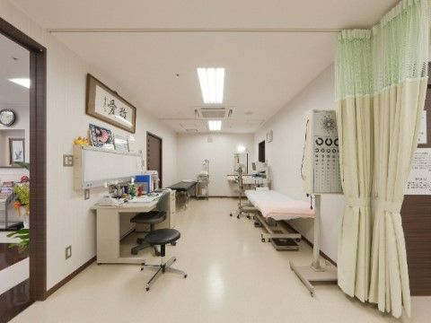 白で統一された衛生的な診察室である。簡易ベッドが２台と視力測定器が完備されている。広々とした空間である。