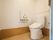 温水洗浄便座のトイレが設置されている。壁にはペーパーホルダーと緊急呼び出しボタンが備え付けられている。