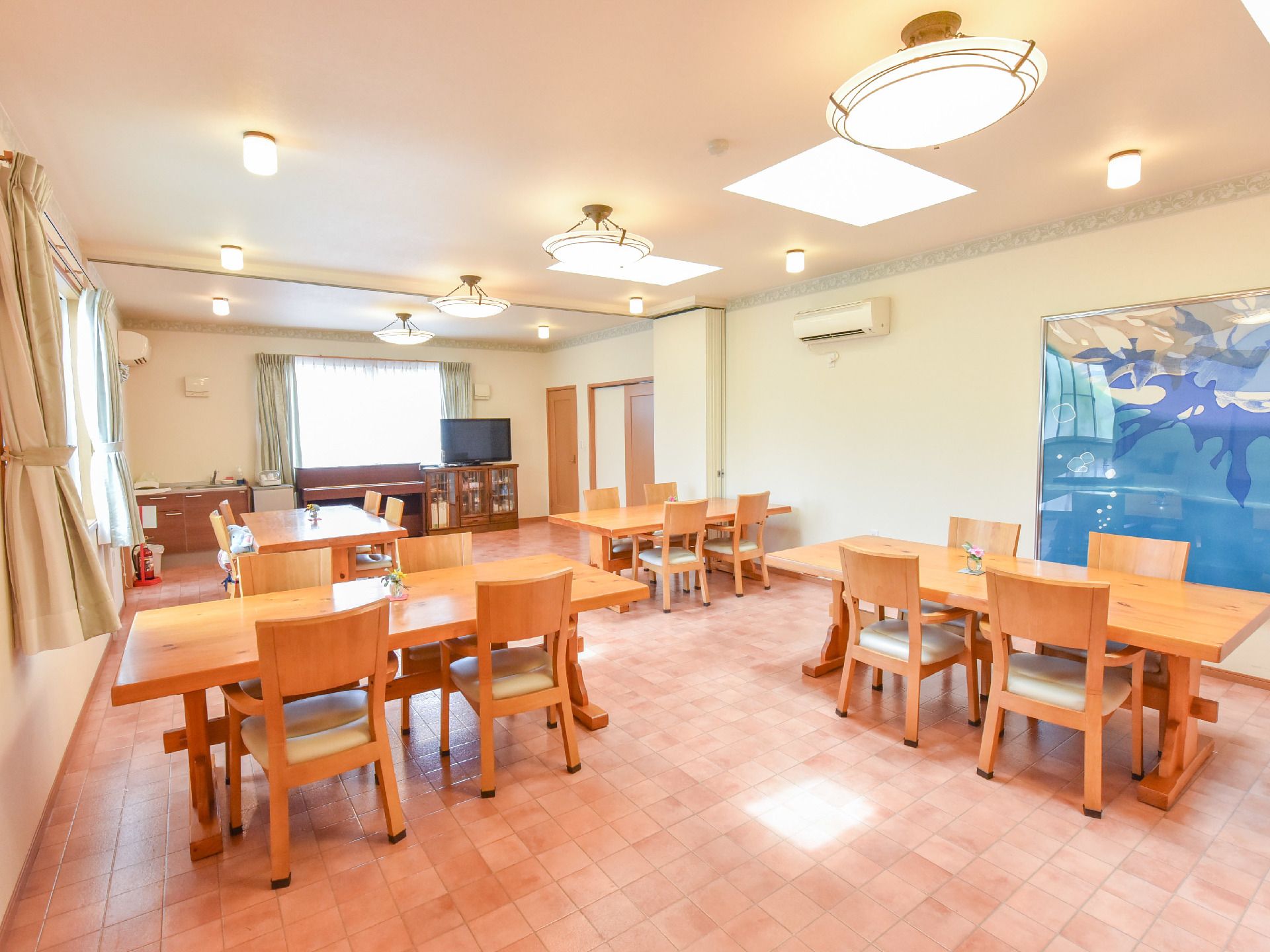 入居者たちが集まって食事をとる食堂。テーブルや椅子が並んで座席になっていて、入り口は力のいらない引き戸。