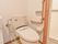 シャワー式のトイレが設置されている。壁には手すりと緊急用の呼び出しボタンが設置され、安心して使用できる。