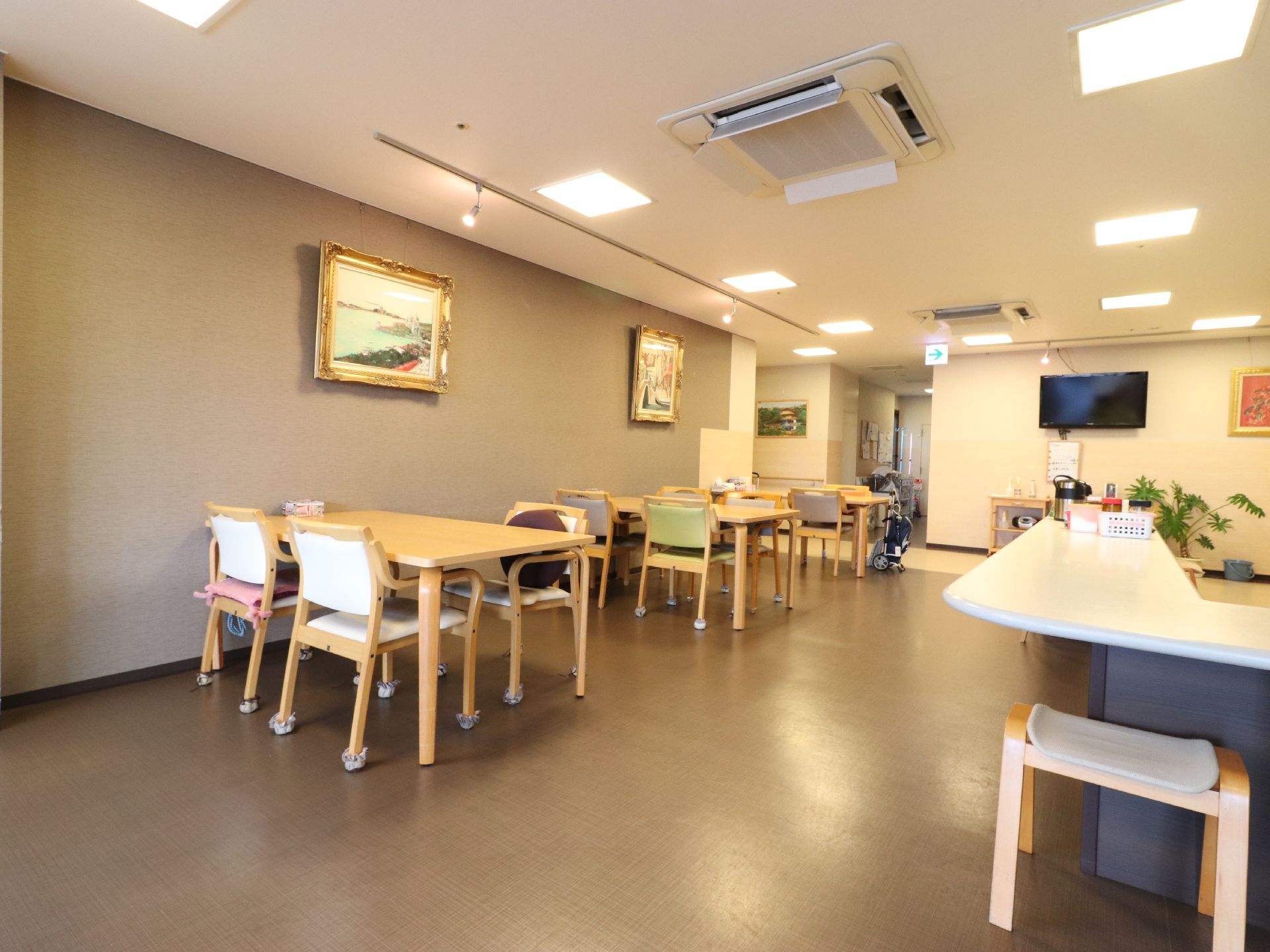 左手にテーブルが三台、椅子が十脚ほど置いてある。壁には絵画が飾られている。カウンターがあり、ポットが置いてある。