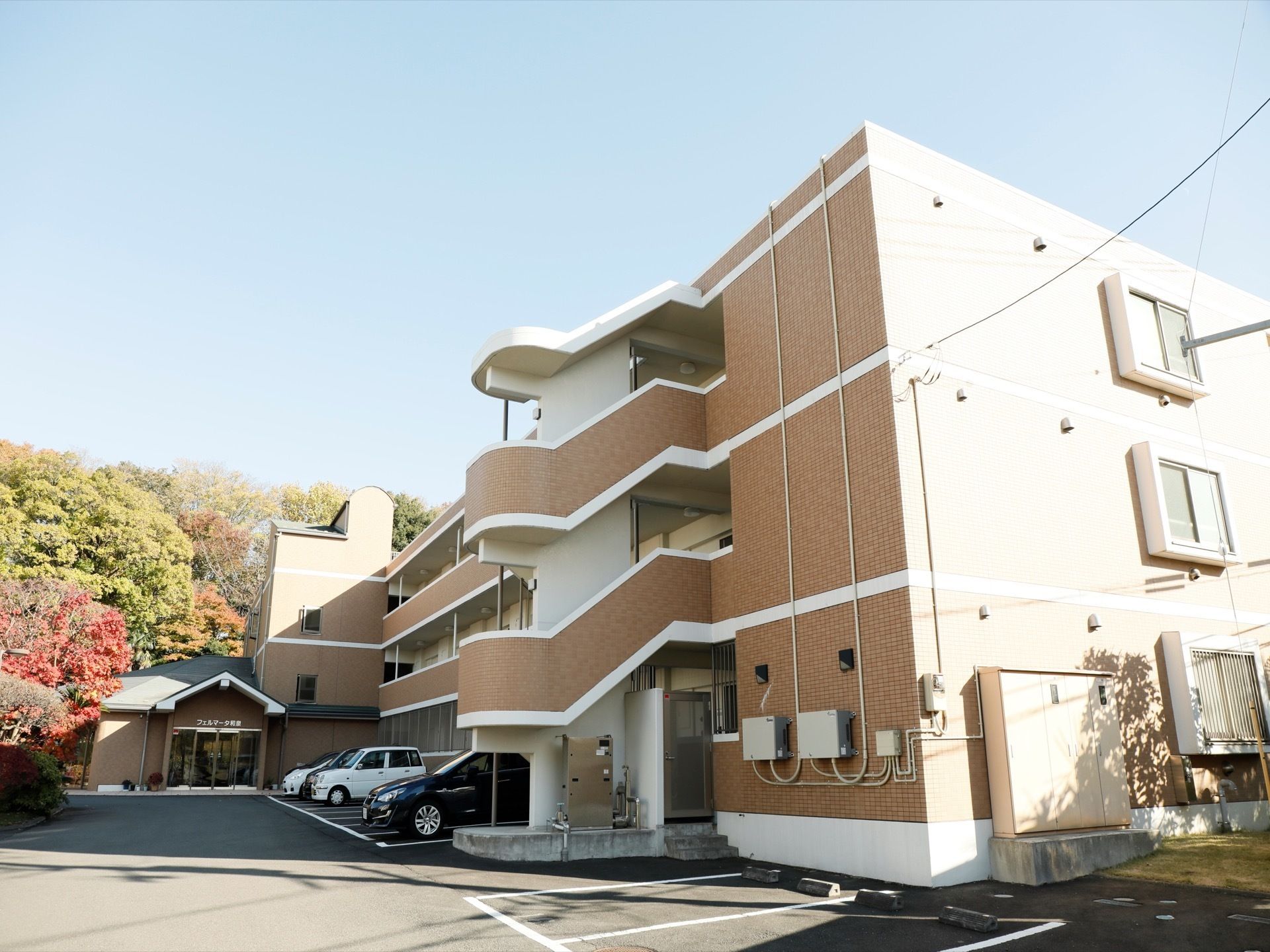 外から見た施設は、通常のマンションのように外階段があり、部屋が並んだつくりをしている。外壁には、オレンジがかった茶色のタイルが貼ってある。